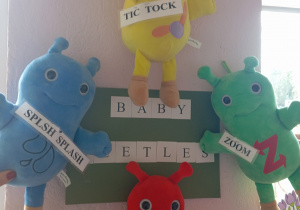 Cztery pluszowe zabawki "Baby Beetles" wiszące na ścianie.