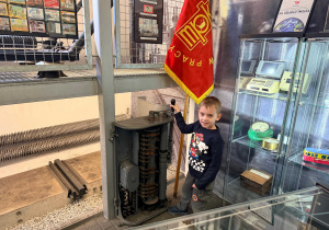 Chłopiec stoi przy maszynie do kierowania starym tramwajem.