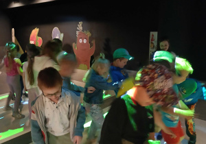 Przedszkolaki stojące na interaktywnej macie w Planetarium.