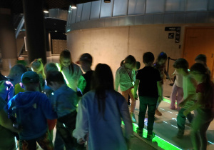 Przedszkolaki stojące na interaktywnej macie w Planetarium.