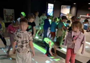 Przedszkolaki stojące na interaktywnej macie w Planetarium.