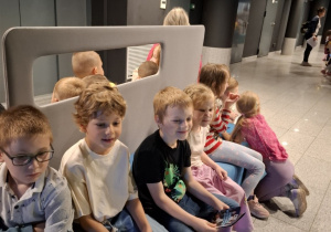 Przedszkolaki siedzą w poczekalni Planetarium.