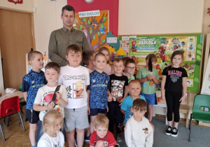 Dzieci pozują do zdjęcia z leśniczym.