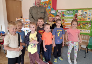 Dzieci pozują do zdjęcia z leśniczym.