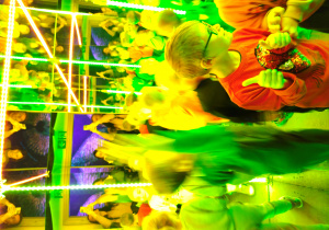 Skaczące dzieci w oświetlonej kolorowymi światłami sali z luster.