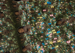 Dziewczynka w oświetlonym kolorowymi światełkami pudle z luster.