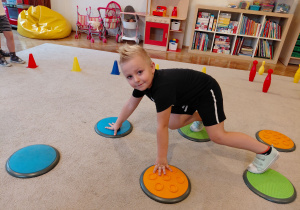 Chłopiec przechodzi po sensorycznych kołach.