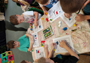 Przedszkolaki wyklejają flagę Francji bibułą.