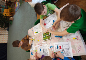 Przedszkolaki wyklejają flagę Francji bibułą.