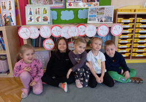 Przedszkolaki siedzące pod obrazkami "zakaz palenia".