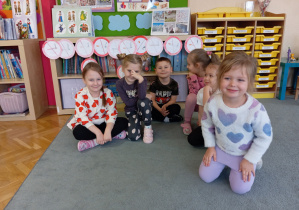 Przedszkolaki siedzące pod obrazkami "zakaz palenia".