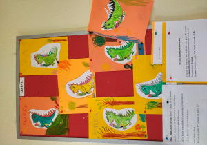 Pokolorowane smoki przypięte do tablicy.